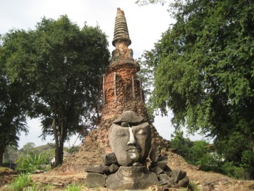 View of a Buddha head on the ruins of the ubosot